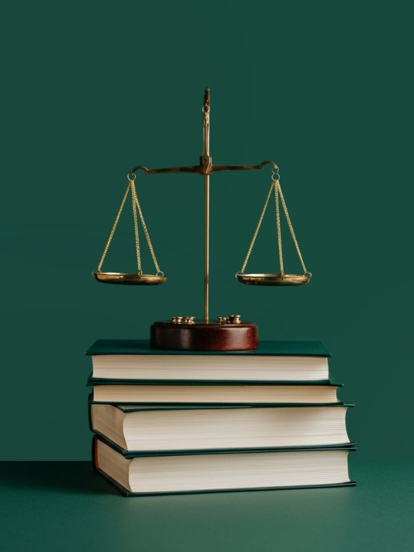 Balança da justiça em cima de uma pilha de livros